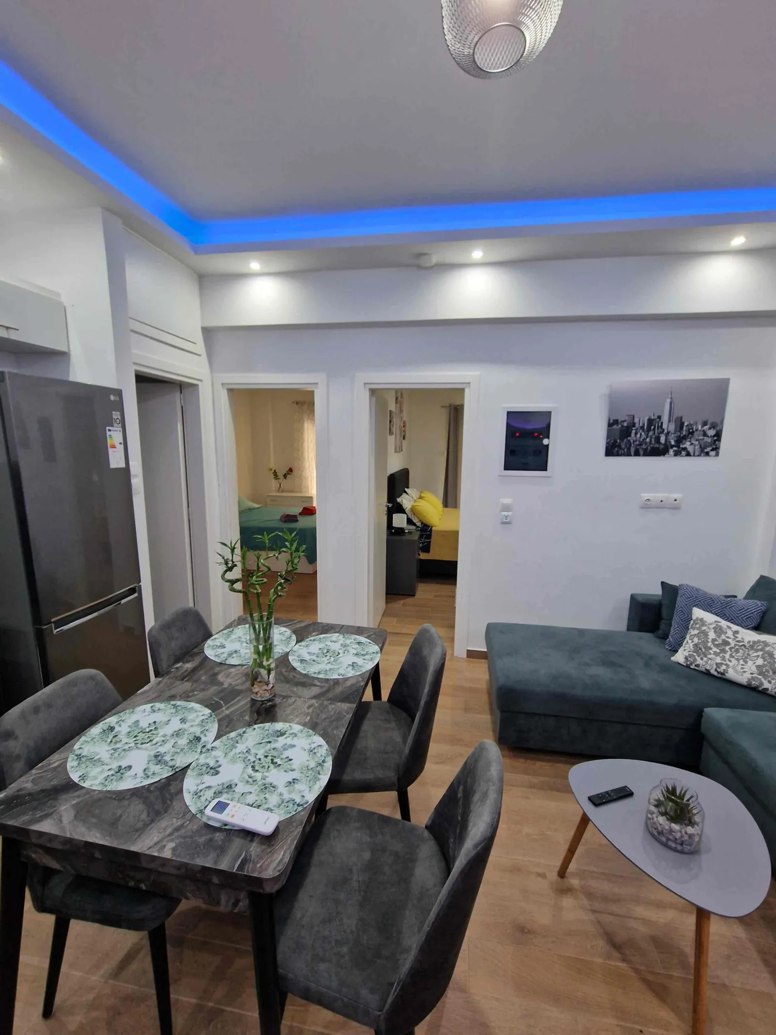 Dining area with marble-effect table under blue cove lighting
