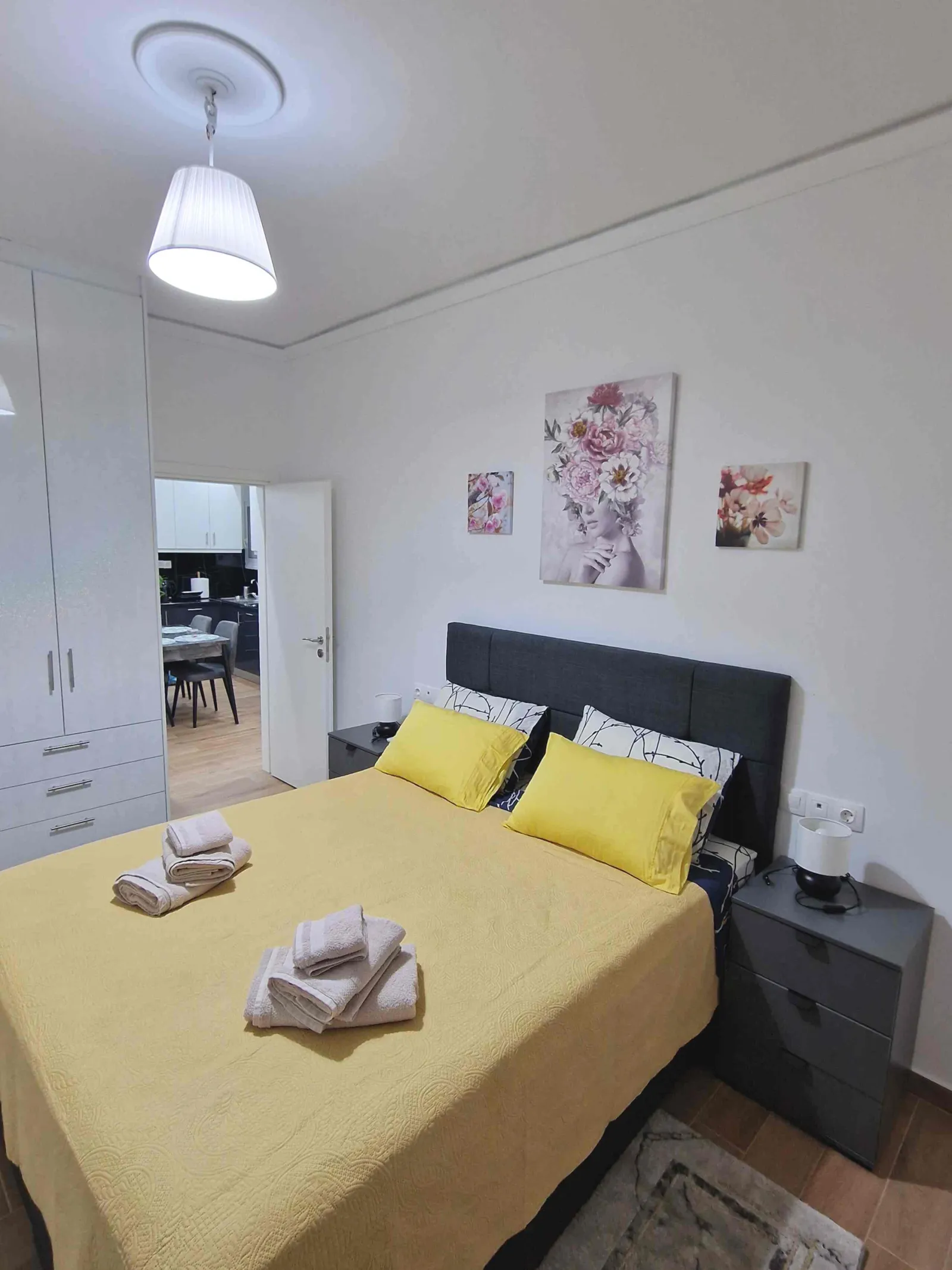 Second bedroom with yellow bedspread and fitted wardrobe